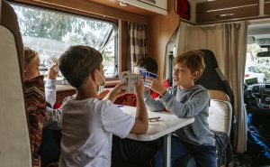 Children playing cards in a caravan