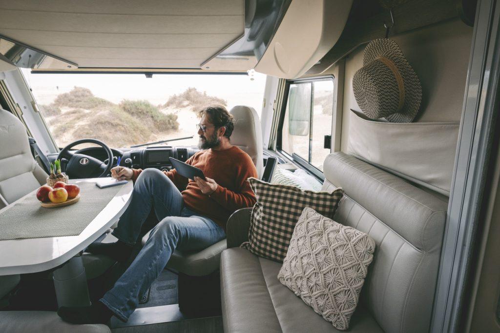 Man With Tablet Pc Sitting In RV writing a list